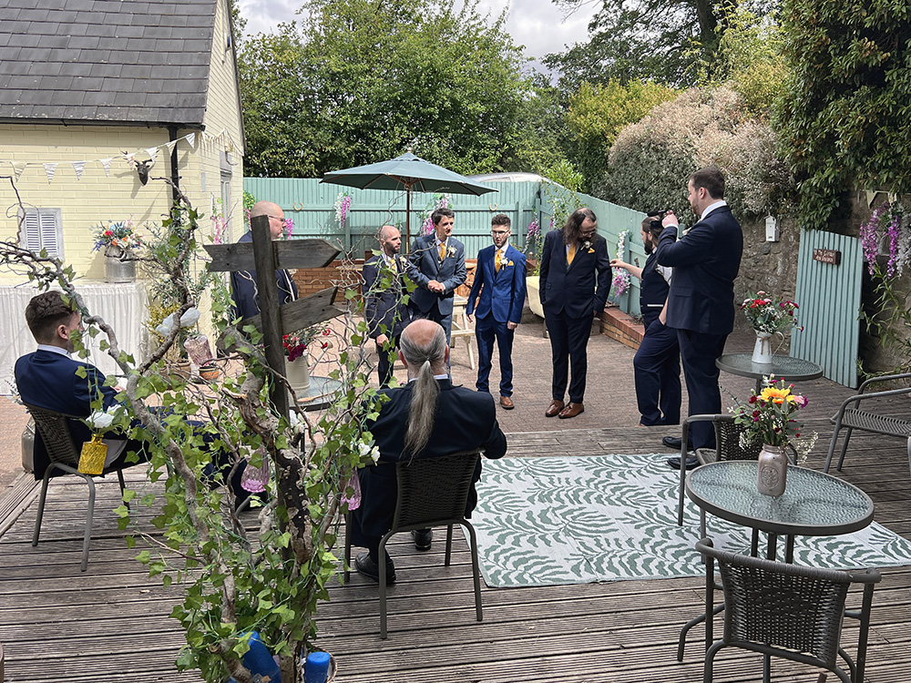 the wedding guests enjoying drinks and live music in the sun